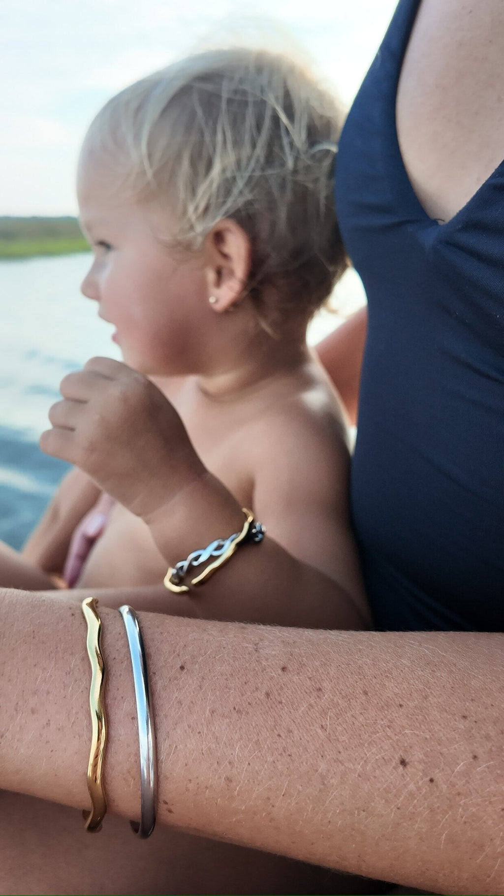 Rose Mini smooth silver bangle on a toddler wrist