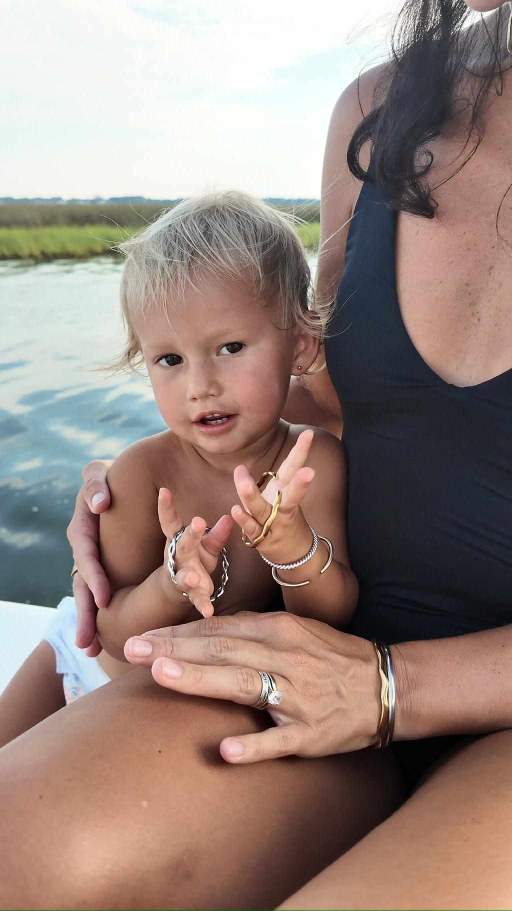 Mother and toddler hands together, both wearing matching Penny Faye bangles