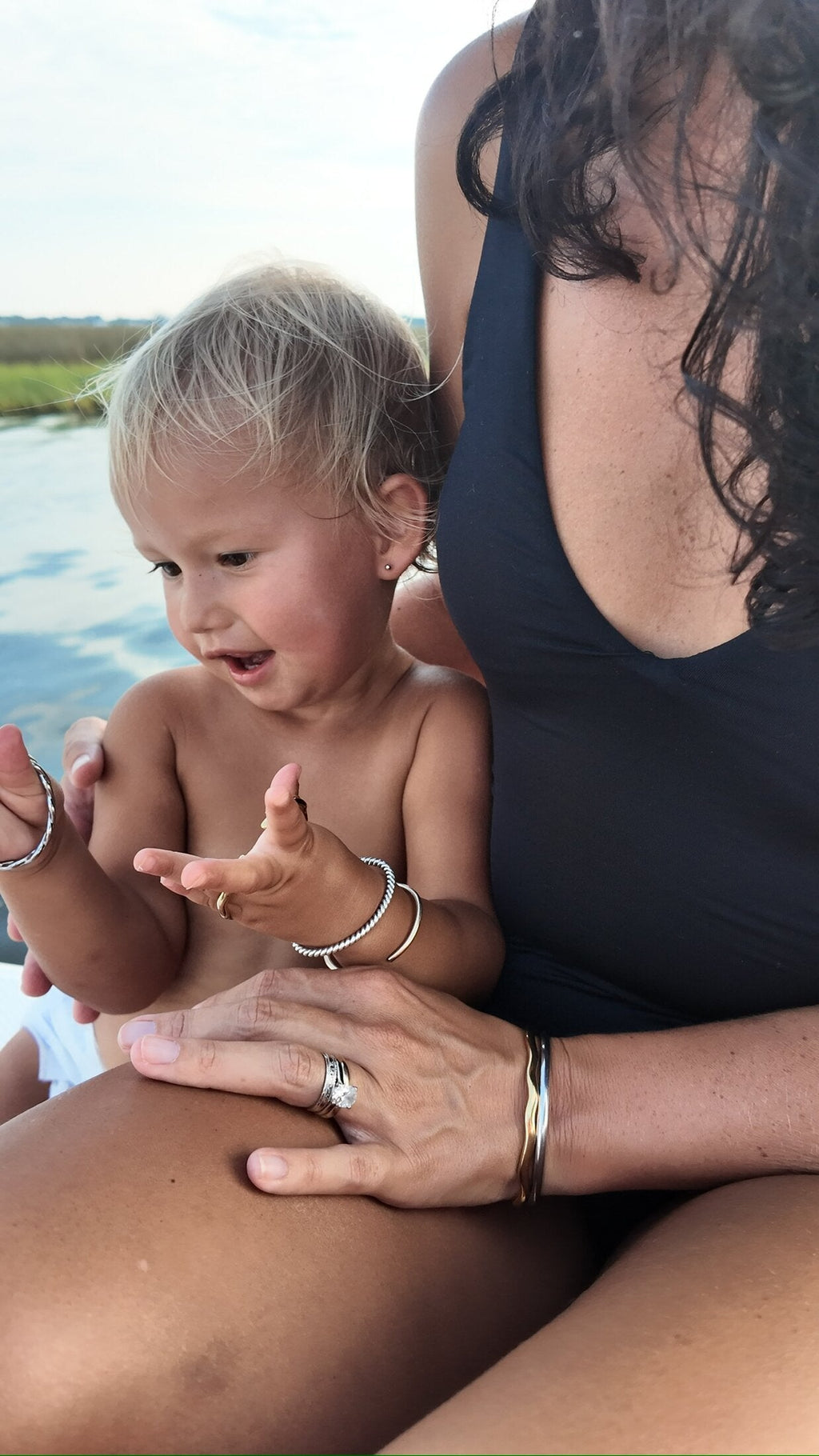 Toddler wearing a Penny Faye Mini bangle reaching out